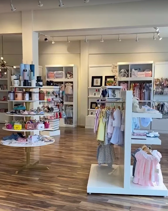 Interior de una tienda con ropa infantil Tiny Bombom en exhibición